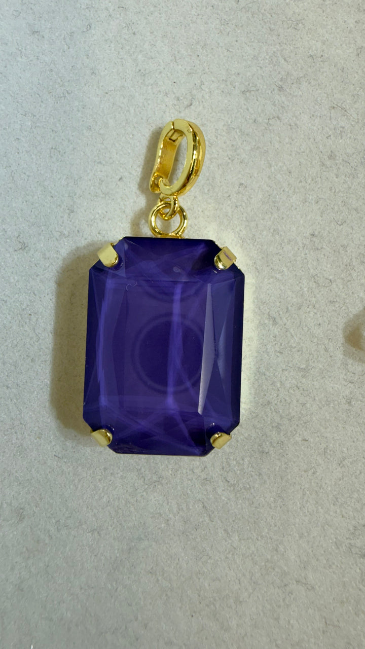 AF Designs rectangular charm with deep violet emerald-cut stone in gold prong setting with spring clasp