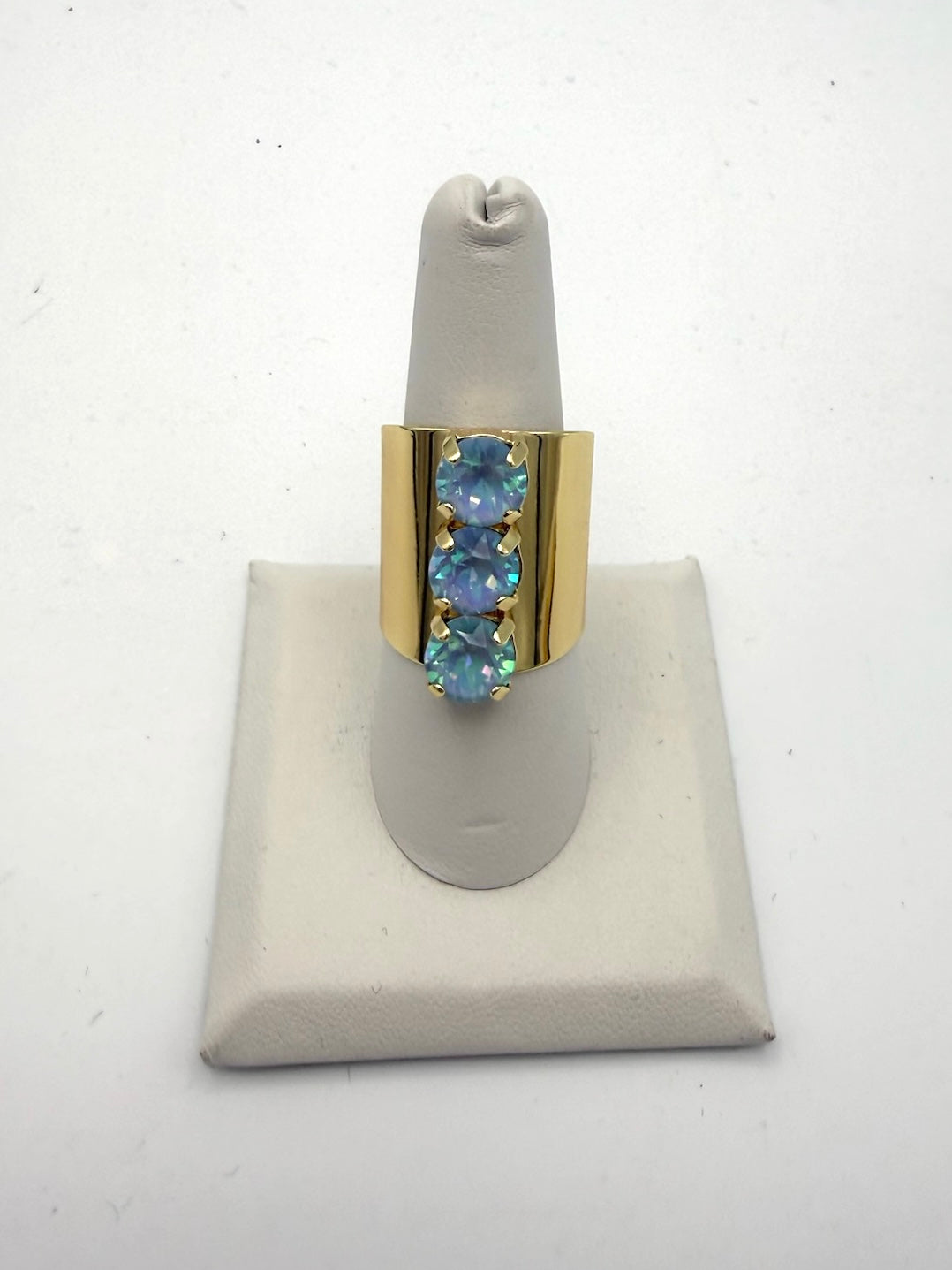 Wide gold-tone ring with three vertically-set round iridescent icy opal crystals in claw settings by AF Designs