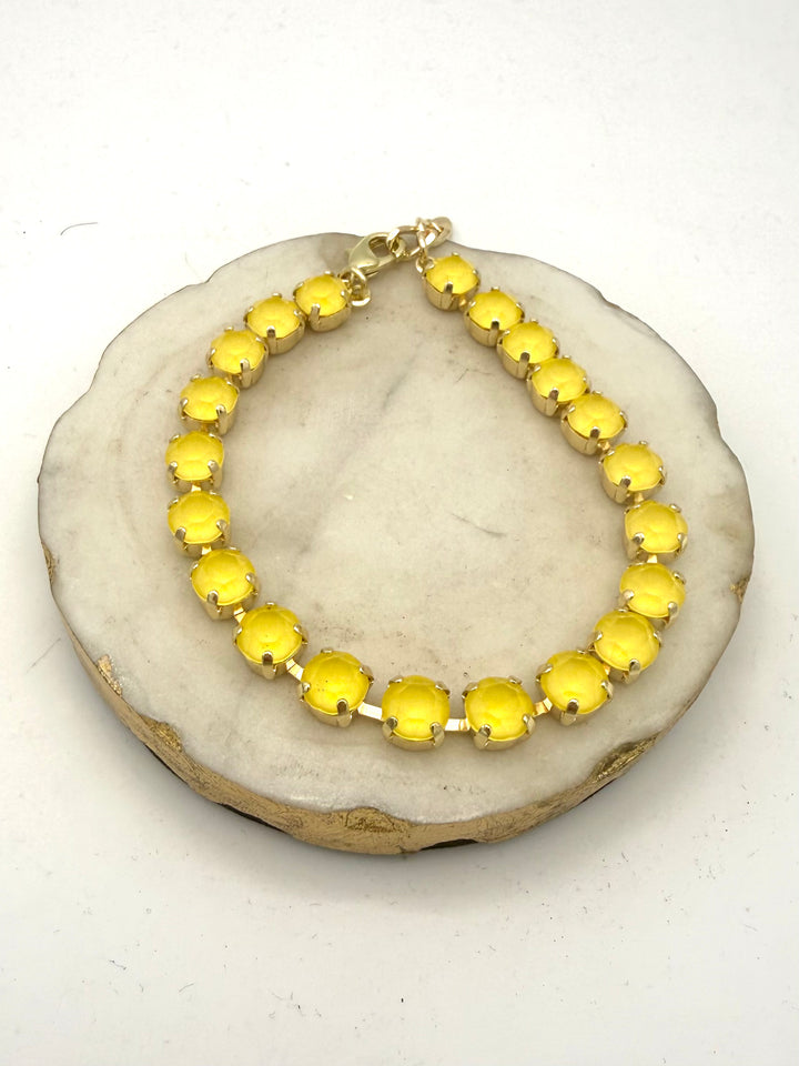 Tennis-style anklet with round opaque yellow gemstones in gold prong settings with lobster clasp closure