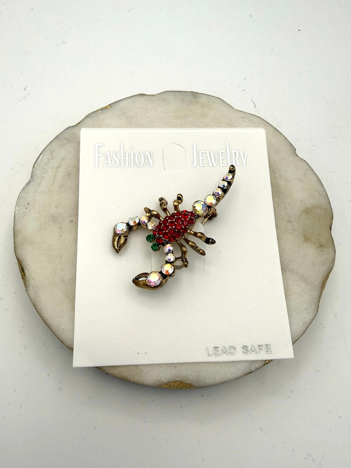 Scorpion brooch pin with red rhinestone body, iridescent crystal tail, and antique gold-tone metal legs