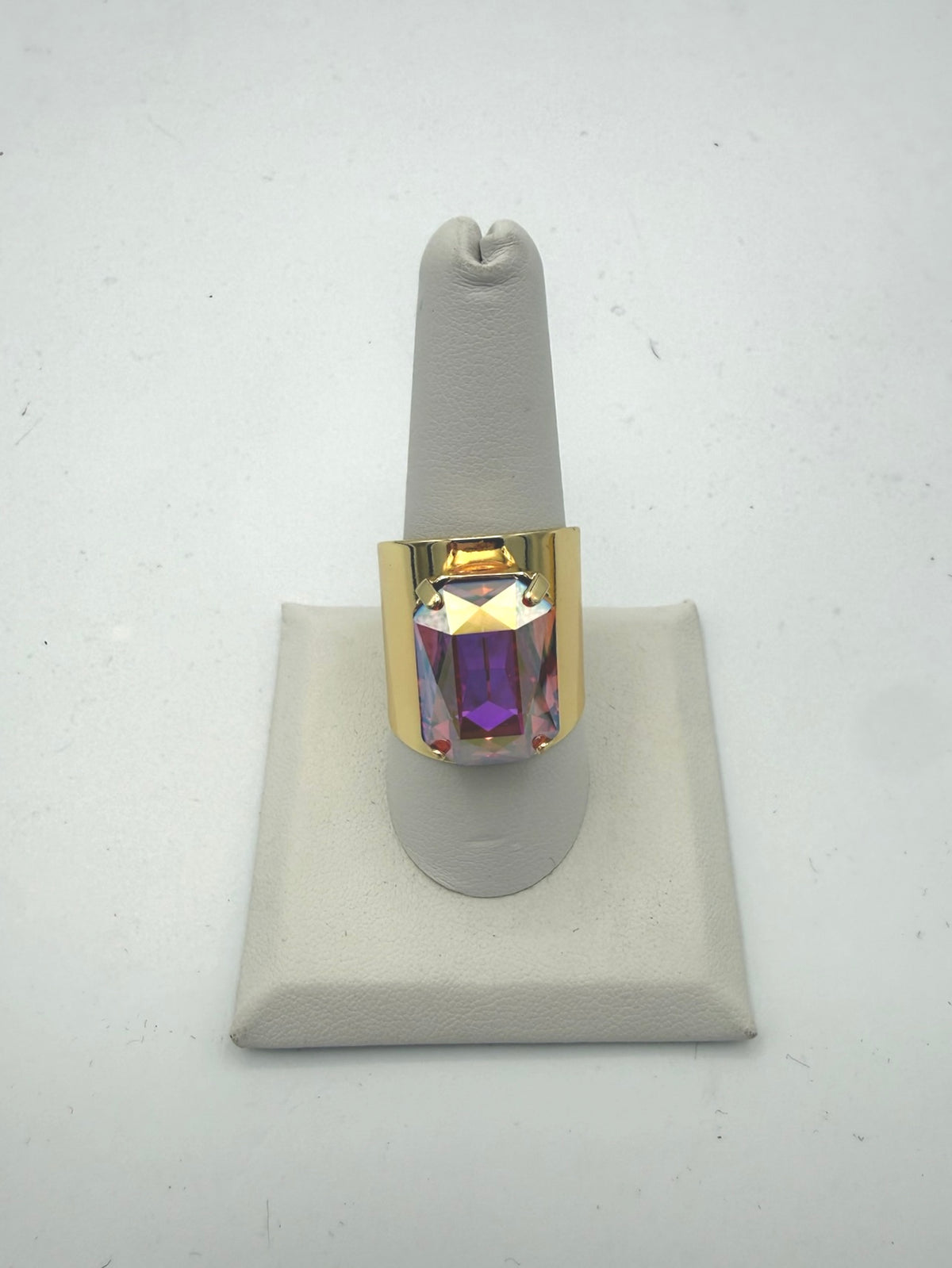 Bold gold cocktail ring with large iridescent fuchsia emerald-cut crystal stone in wide band setting