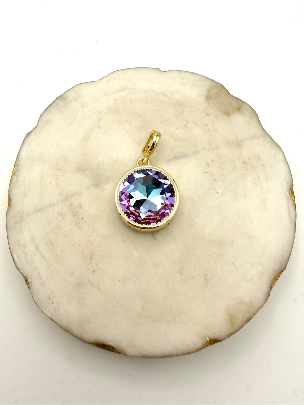 Round gold bezel pendant charm with iridescent lavender AB crystal stone, scalloped edge setting with bail loop.