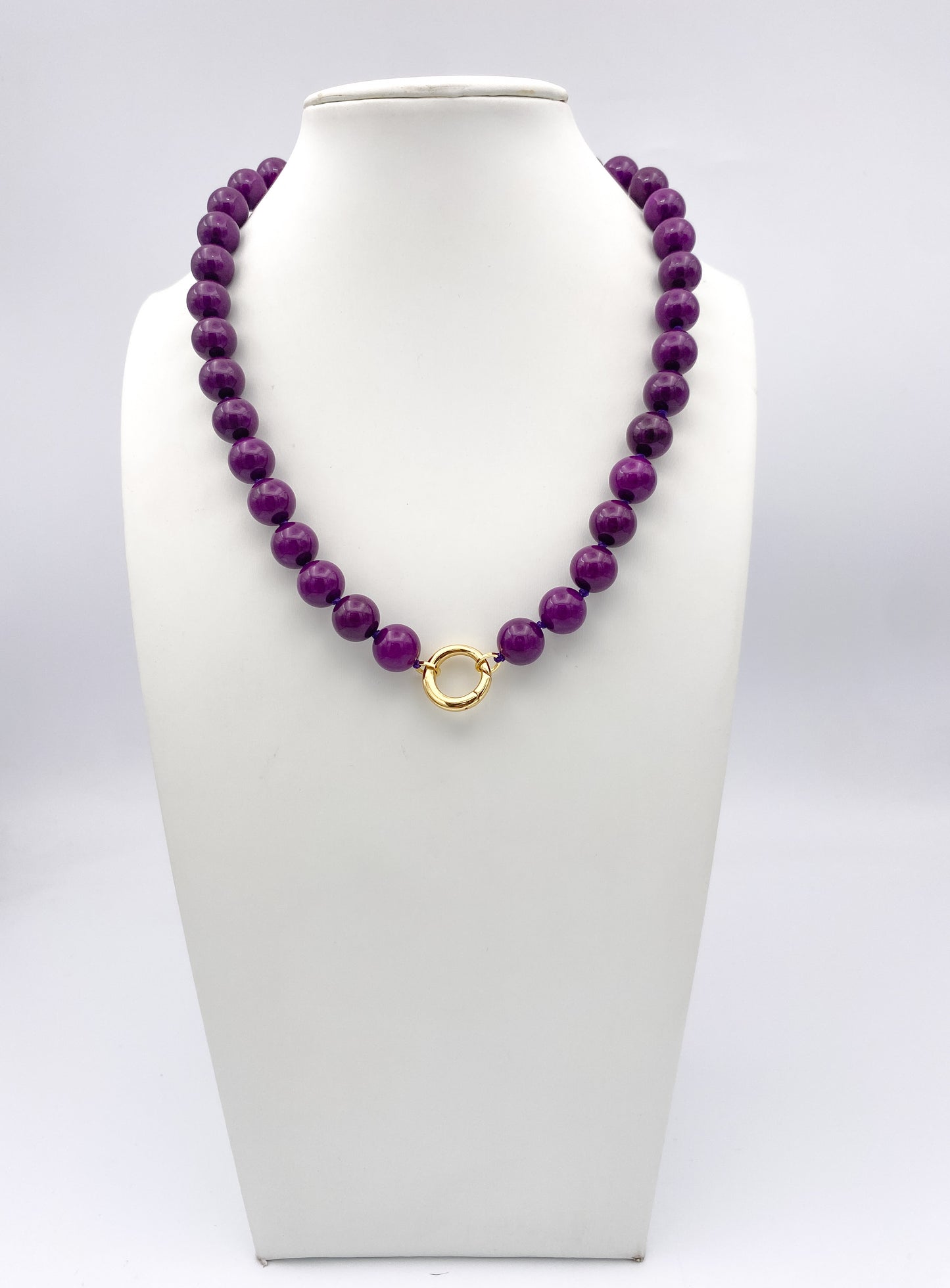AF Designs Amethyst Beauty Necklace: large round purple beaded strand with gold circular clasp on white jewelry bust