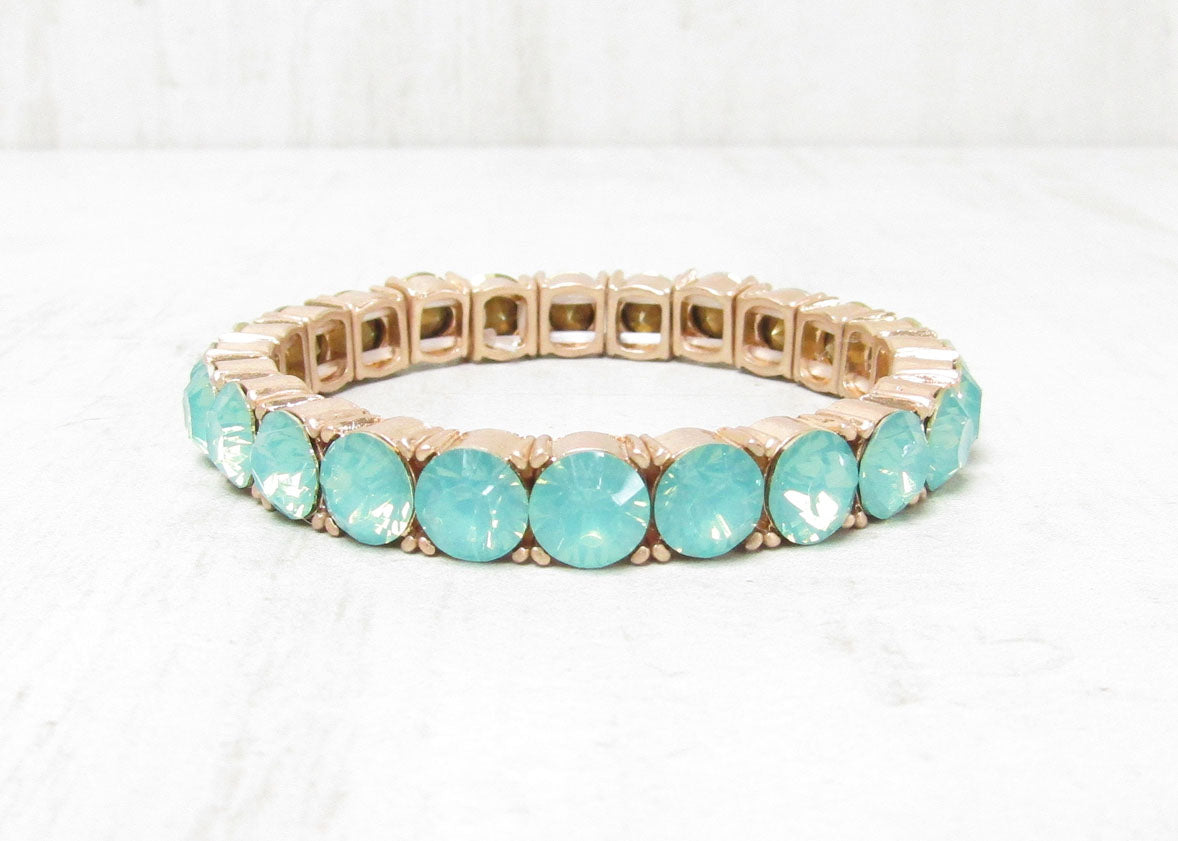 Pacific opal crystal stretch tennis bracelet with rose gold settings on white background