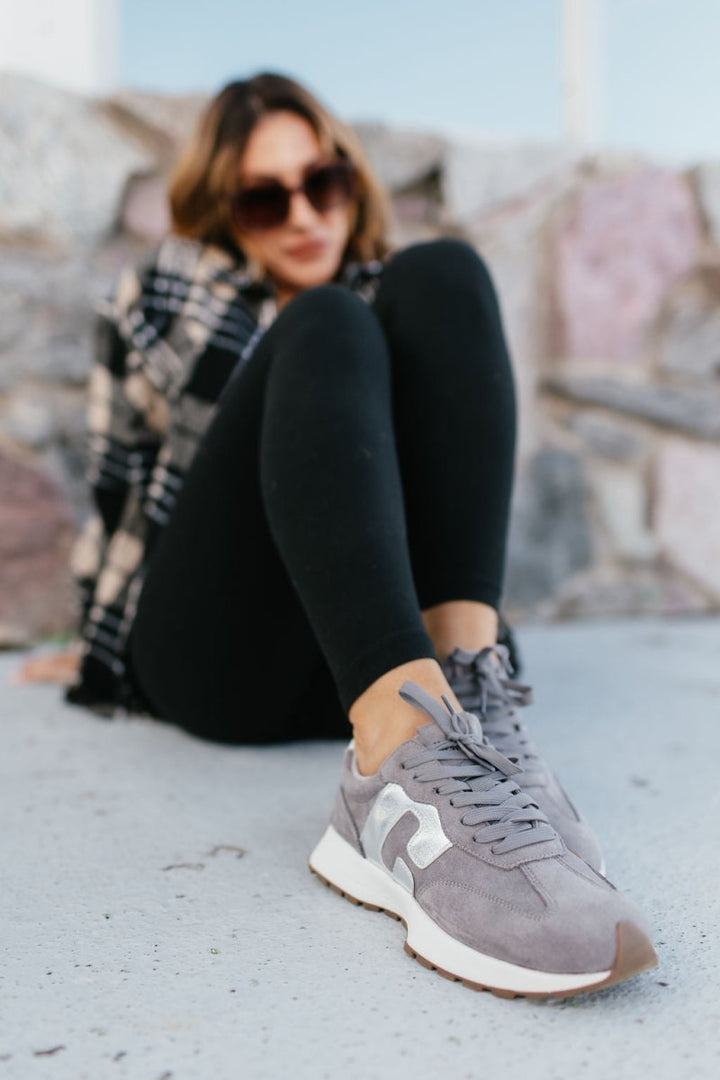 Corky's Grey Faux Suede No Prob Sneakers worn with black leggings, lace-up retro runner with white sole