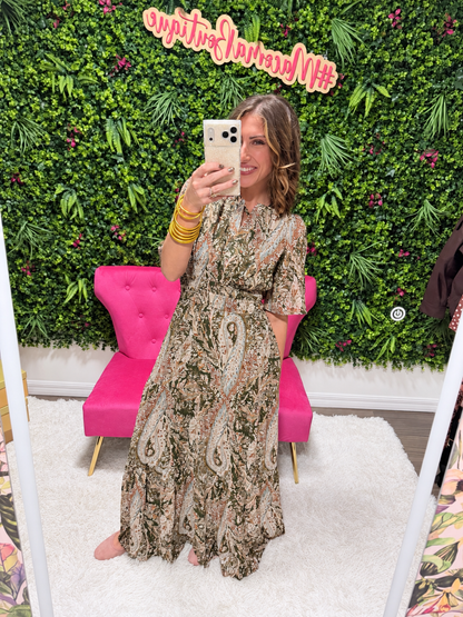 Front view of the olive paisley Wander With Me maxi dress with split ruffle neckline, flutter sleeves and smocked waist, styled with gold bangles
