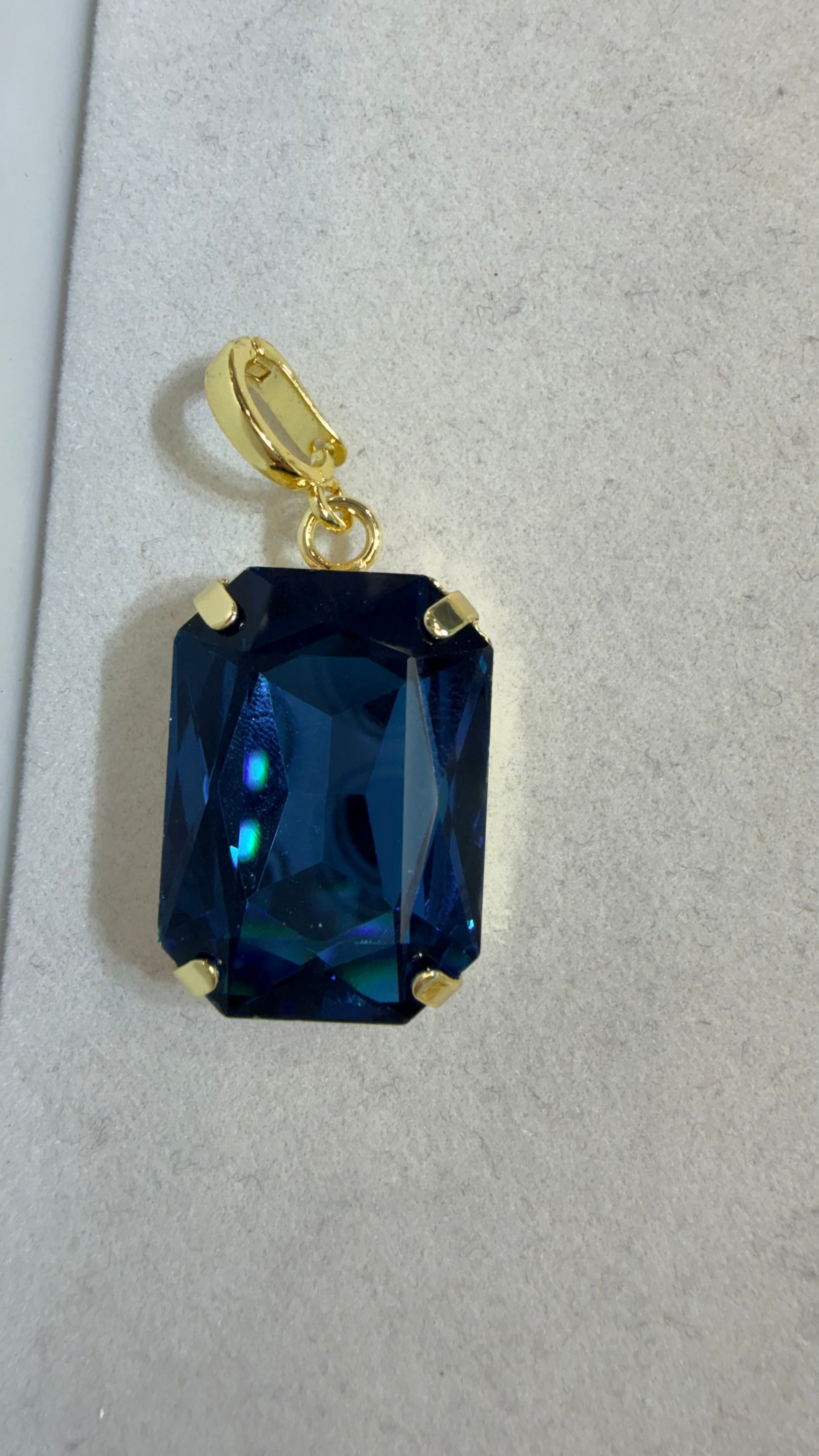 AF Designs gold-tone rectangular pendant with large faceted deep blue crystal stone in four-prong setting