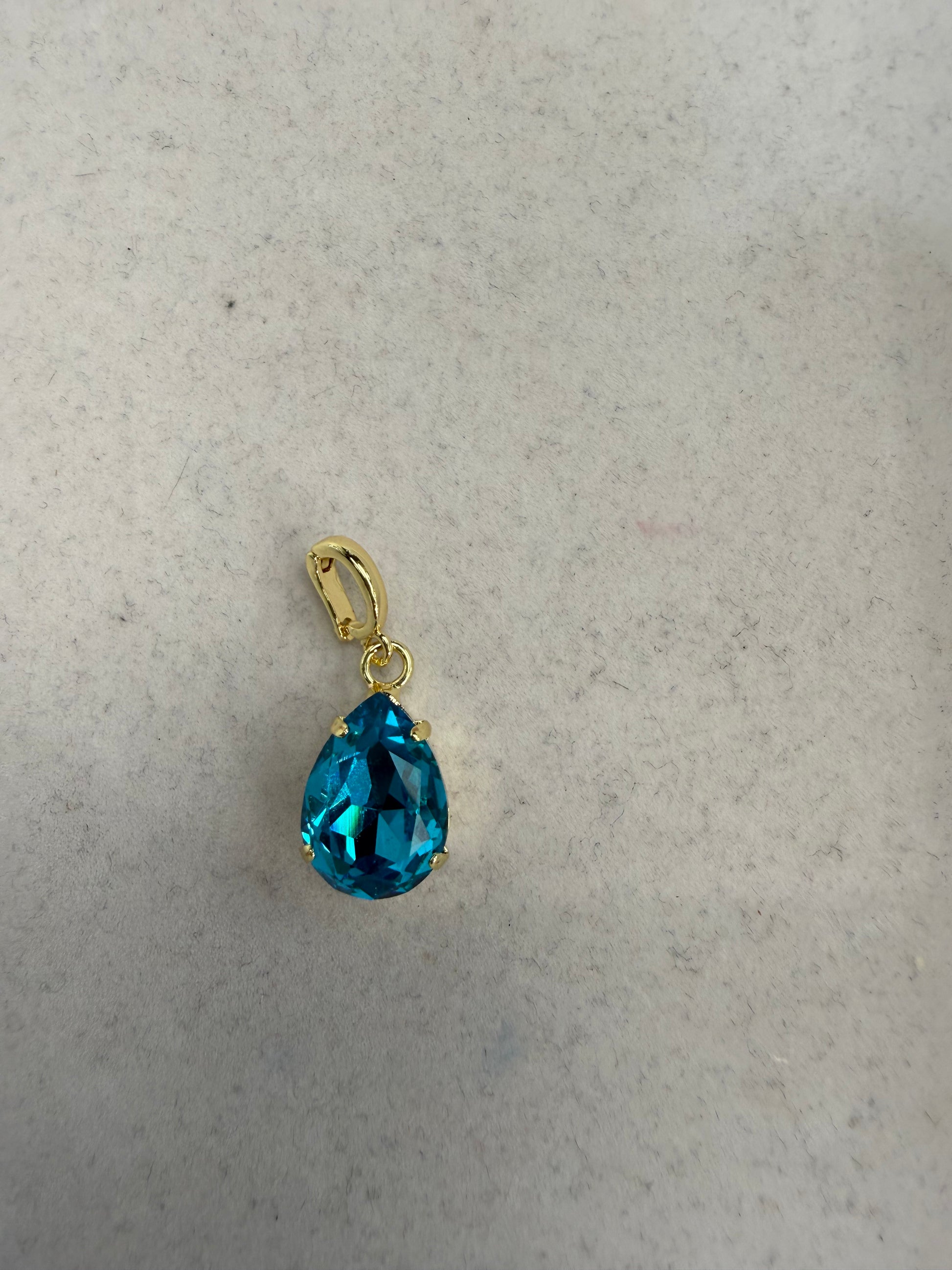 AF Designs teardrop charm with lagoon blue faceted gemstone in gold prong setting with bail clasp