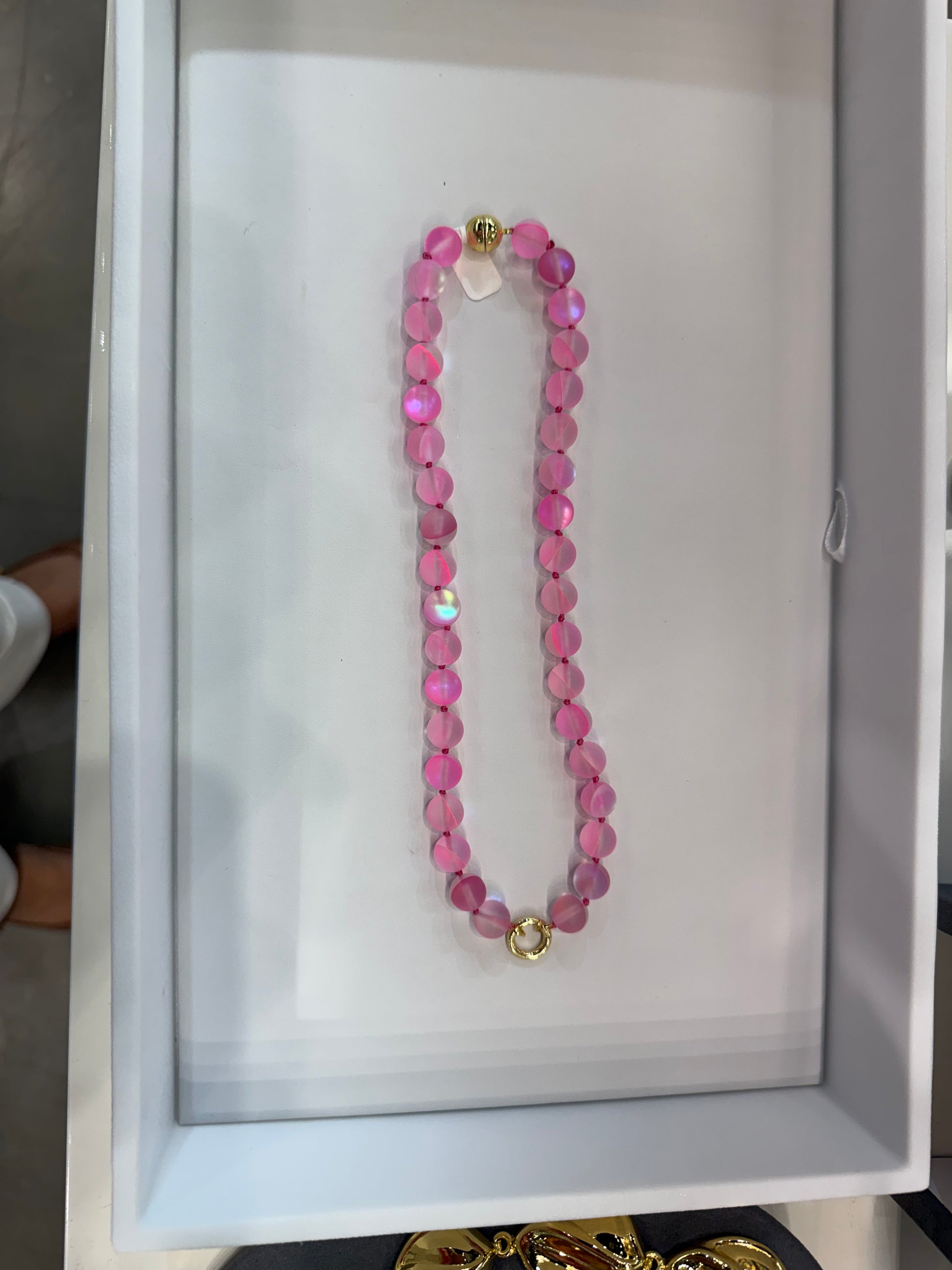 AF Designs 10mm cotton candy pink iridescent beaded necklace with gold clasp and knotted cord detailing.