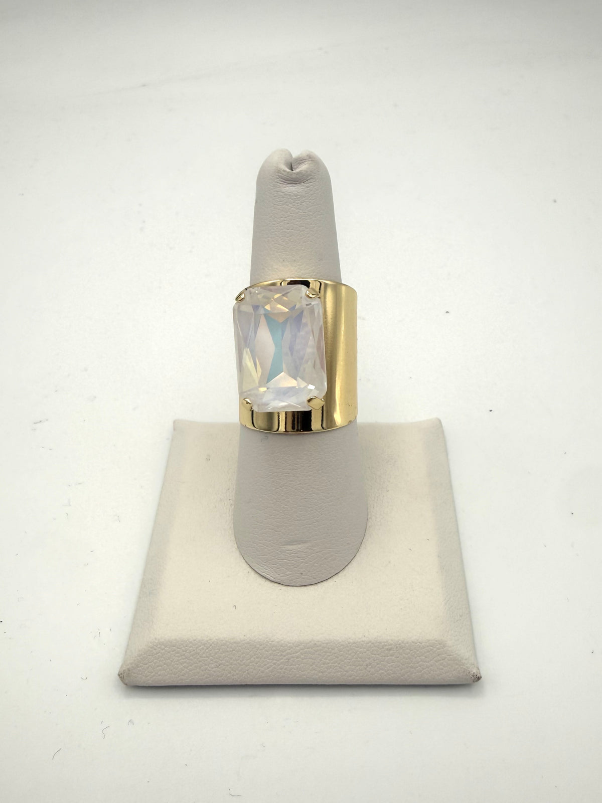 Bold gold wide-band cocktail ring with large iridescent emerald-cut opalescent crystal stone