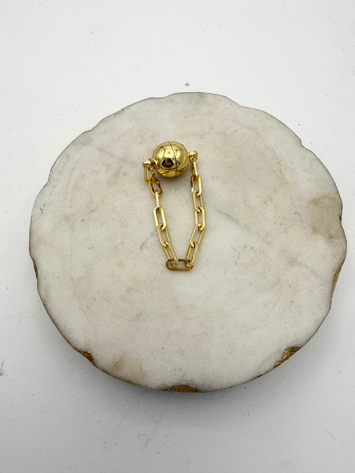 4-inch gold magnetic jewelry extender with spherical clasp and paperclip chain links on marble display
