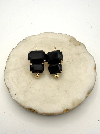 Black double emerald-cut crystal drop earrings with gold prong settings and French hook closures by AF Designs.