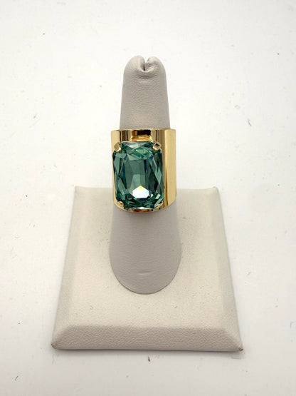 Bold gold-tone wide band cocktail ring with large cushion-cut ocean teal faceted crystal stone