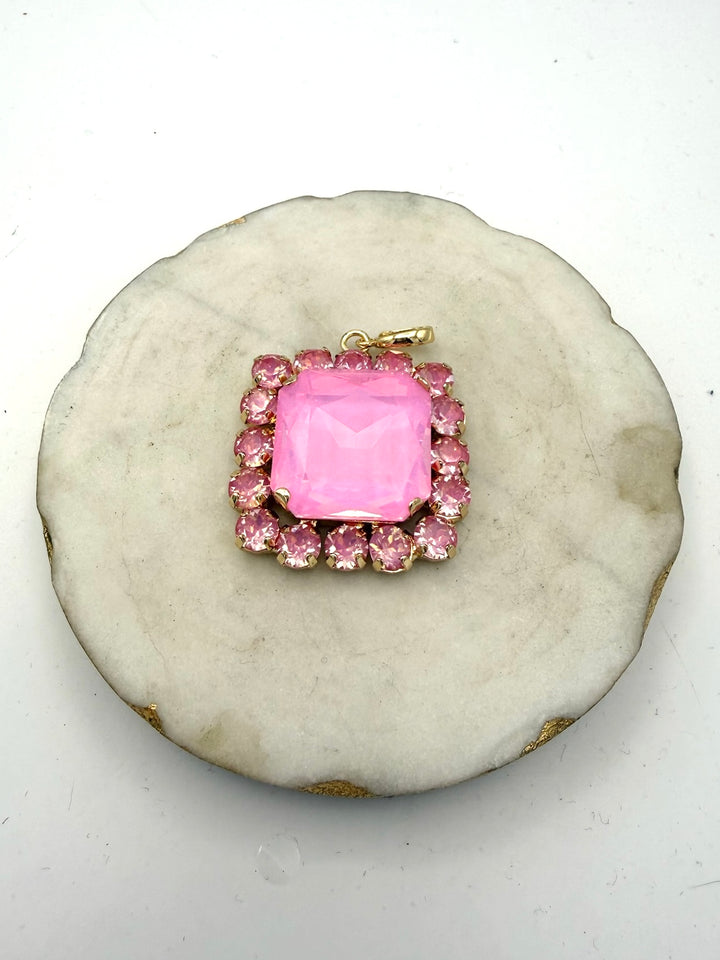 Gold charm pendant with large square bubblegum pink center stone surrounded by pink rhinestone halo border