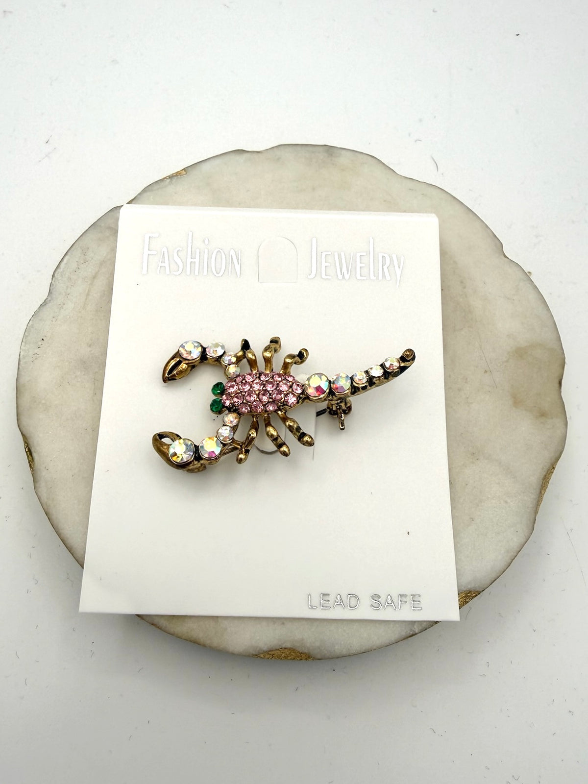 Gold-toned scorpion brooch with pink pavé crystals, iridescent AB rhinestones, and green eye accents.