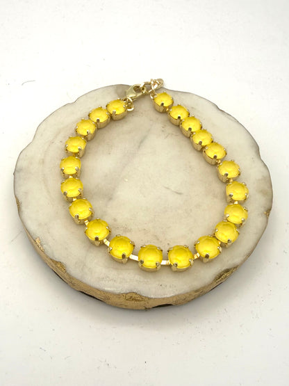 Tennis-style anklet with round opaque yellow gemstones in gold prong settings with lobster clasp closure