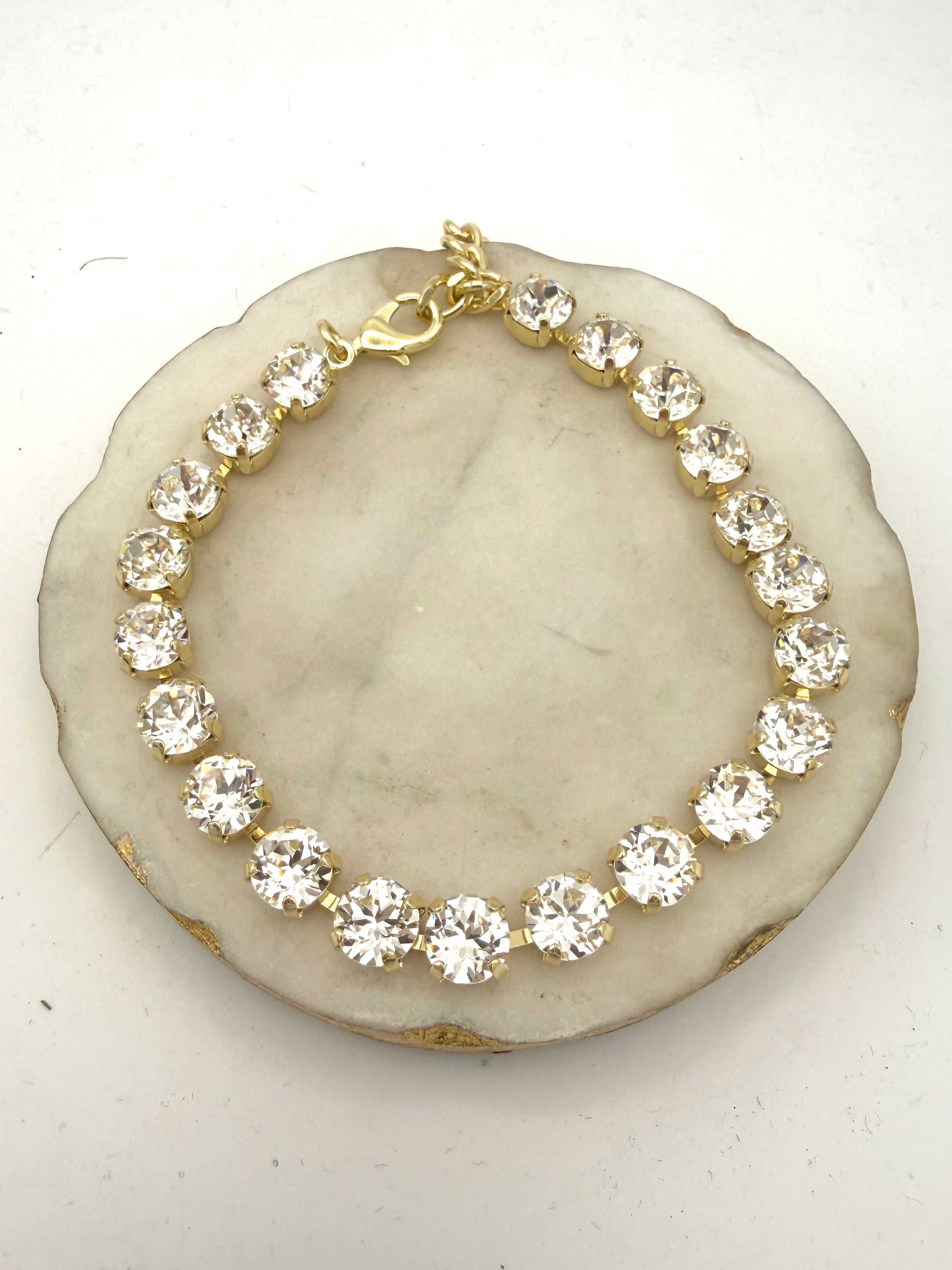 Gold tennis anklet with round clear crystal stones in prong settings and lobster clasp closure