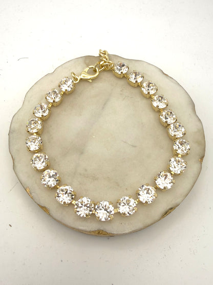 Gold tennis anklet with round clear crystal stones in prong settings and lobster clasp closure