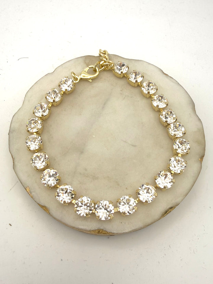 Gold tennis anklet with round clear crystal stones in prong settings and lobster clasp closure