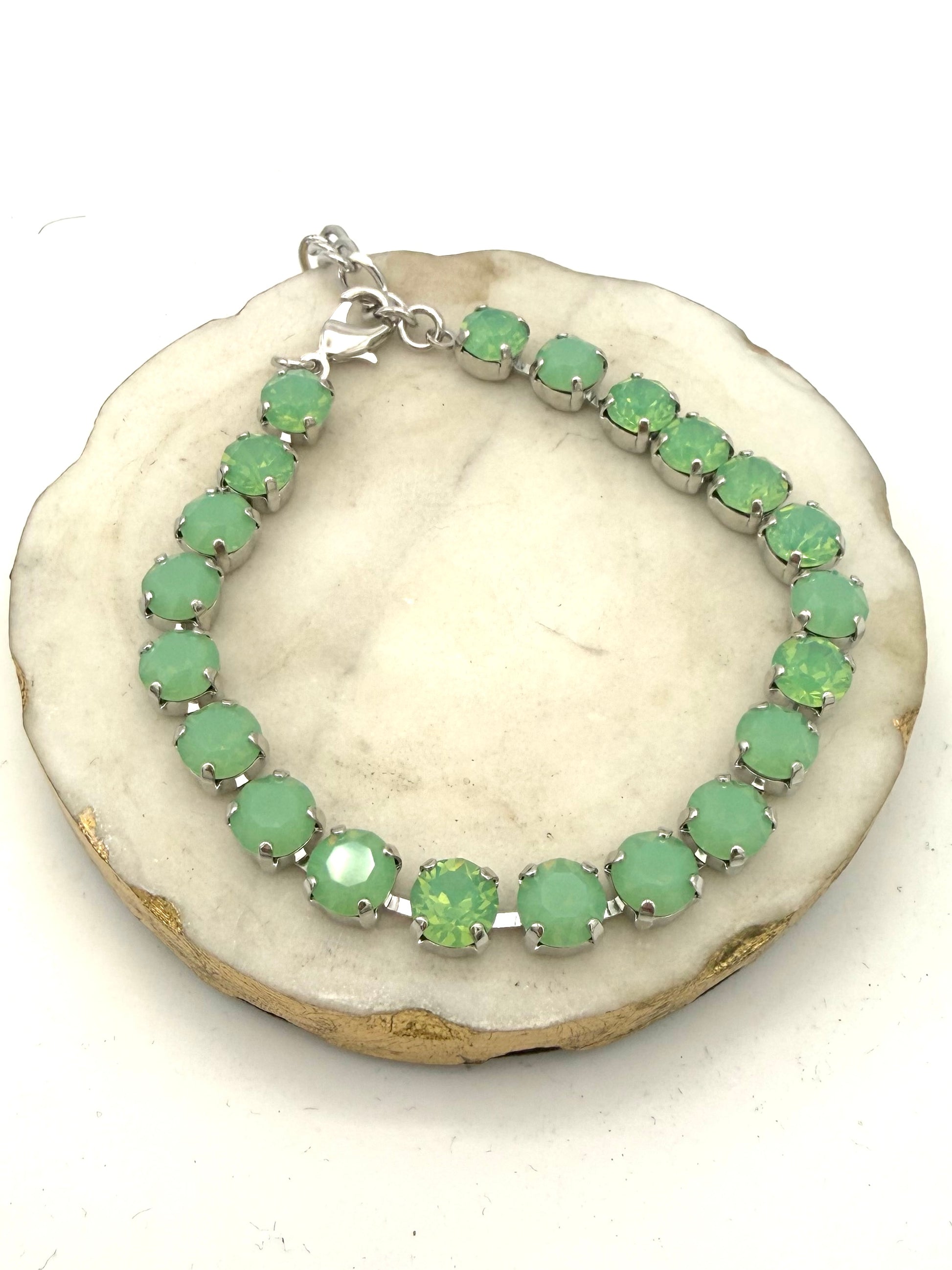 Silver tennis bracelet/anklet with mint green opalescent round crystals in prong settings with lobster clasp closure.