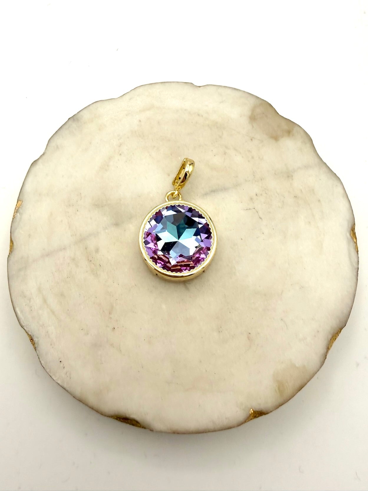 Round gold bezel pendant charm with iridescent lavender AB crystal stone, scalloped edge setting with bail loop.