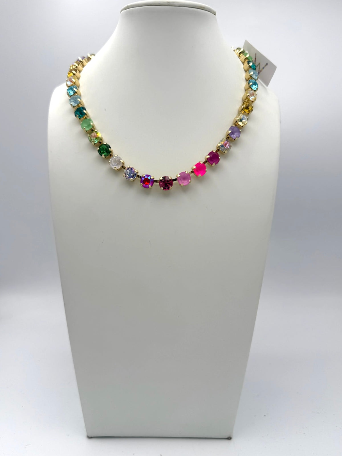 Multicolor rainbow crystal tennis necklace in gold settings featuring pink, purple, blue, green, and yellow stones