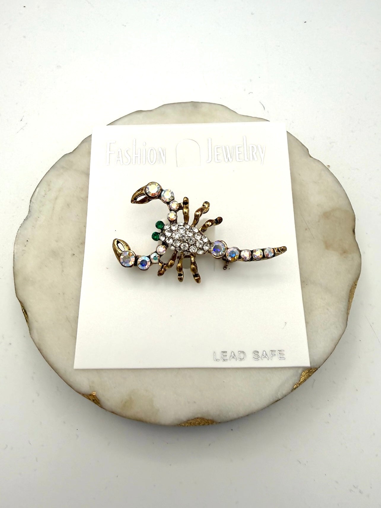 Antique gold scorpion brooch with clear pavé crystals, iridescent AB rhinestones, and emerald green accents.