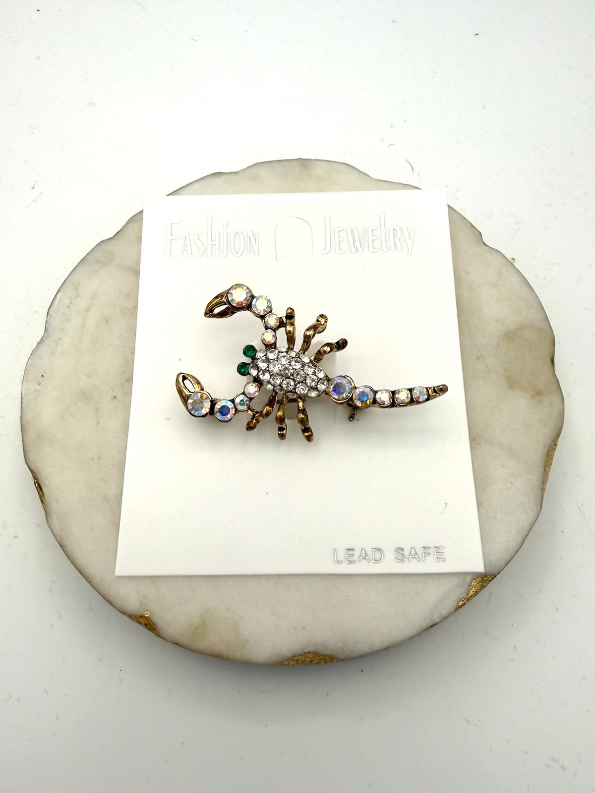 Antique gold scorpion brooch with clear pavé crystals, iridescent AB rhinestones, and emerald green accents.