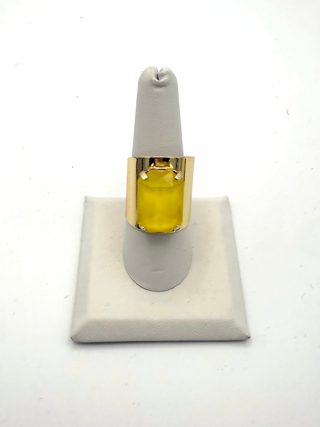 Bold gold-tone wide band cocktail ring featuring a large translucent yellow emerald-cut center stone with prong setting.