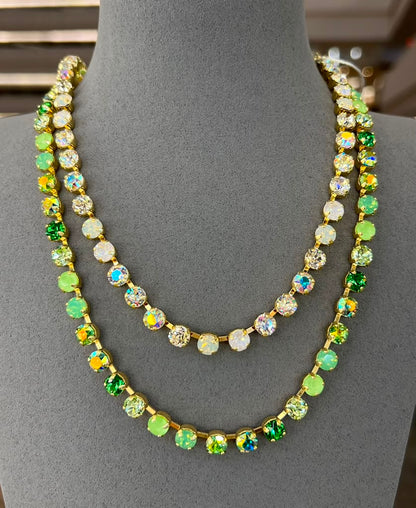Two layered crystal tennis necklaces in gold setting - one with clear stones, one with green mixed crystals