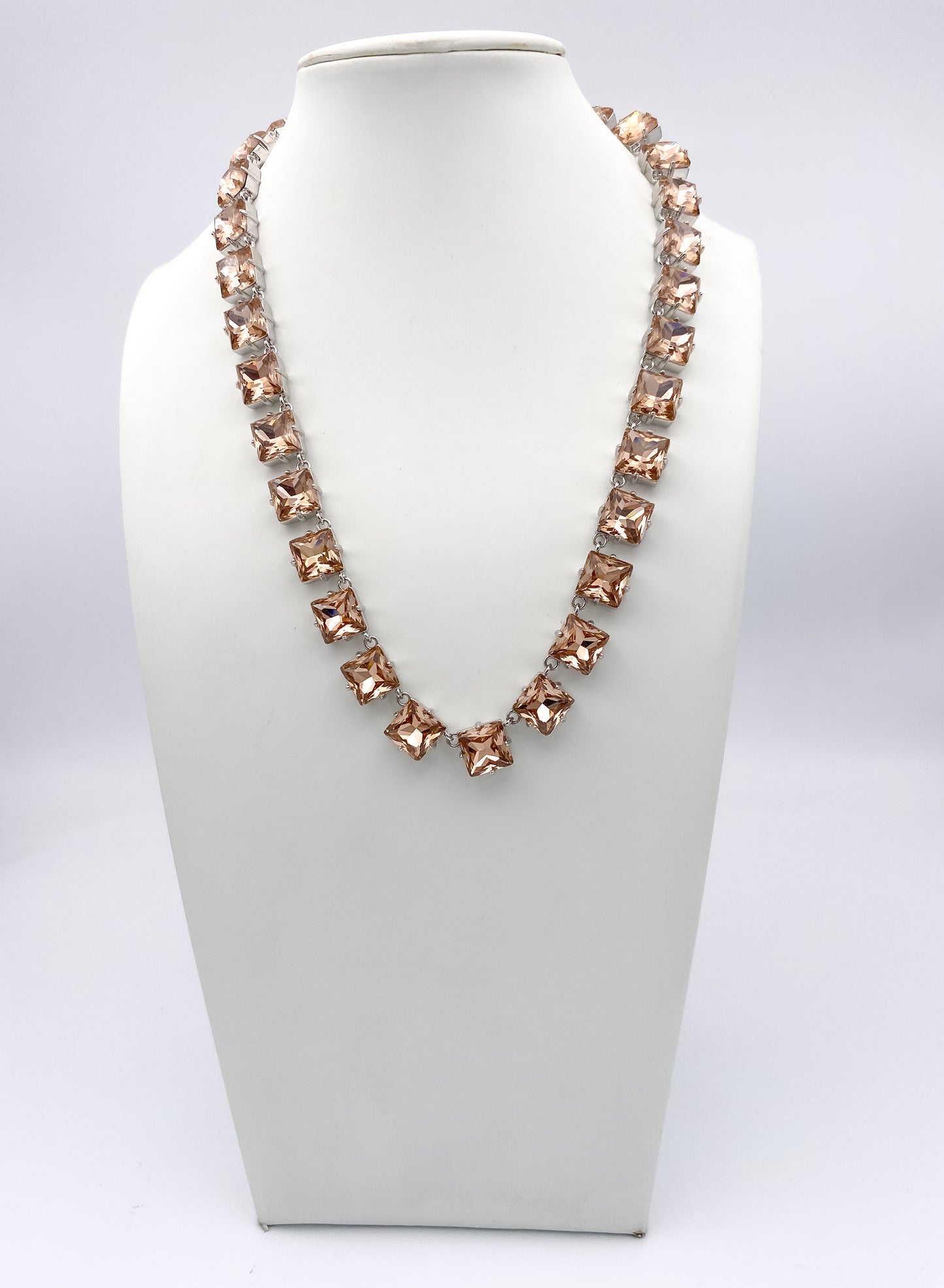 AF Designs square-cut champagne pink crystal tennis necklace with silver prong settings in elegant V-drape style