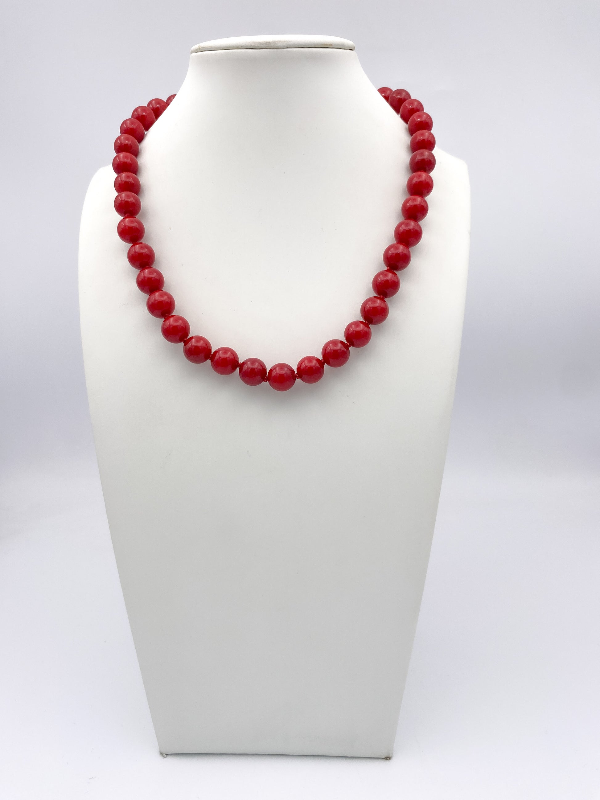 AF Designs Scarlet Romance Necklace: single-strand glossy red round beads, princess length, on white bust form.