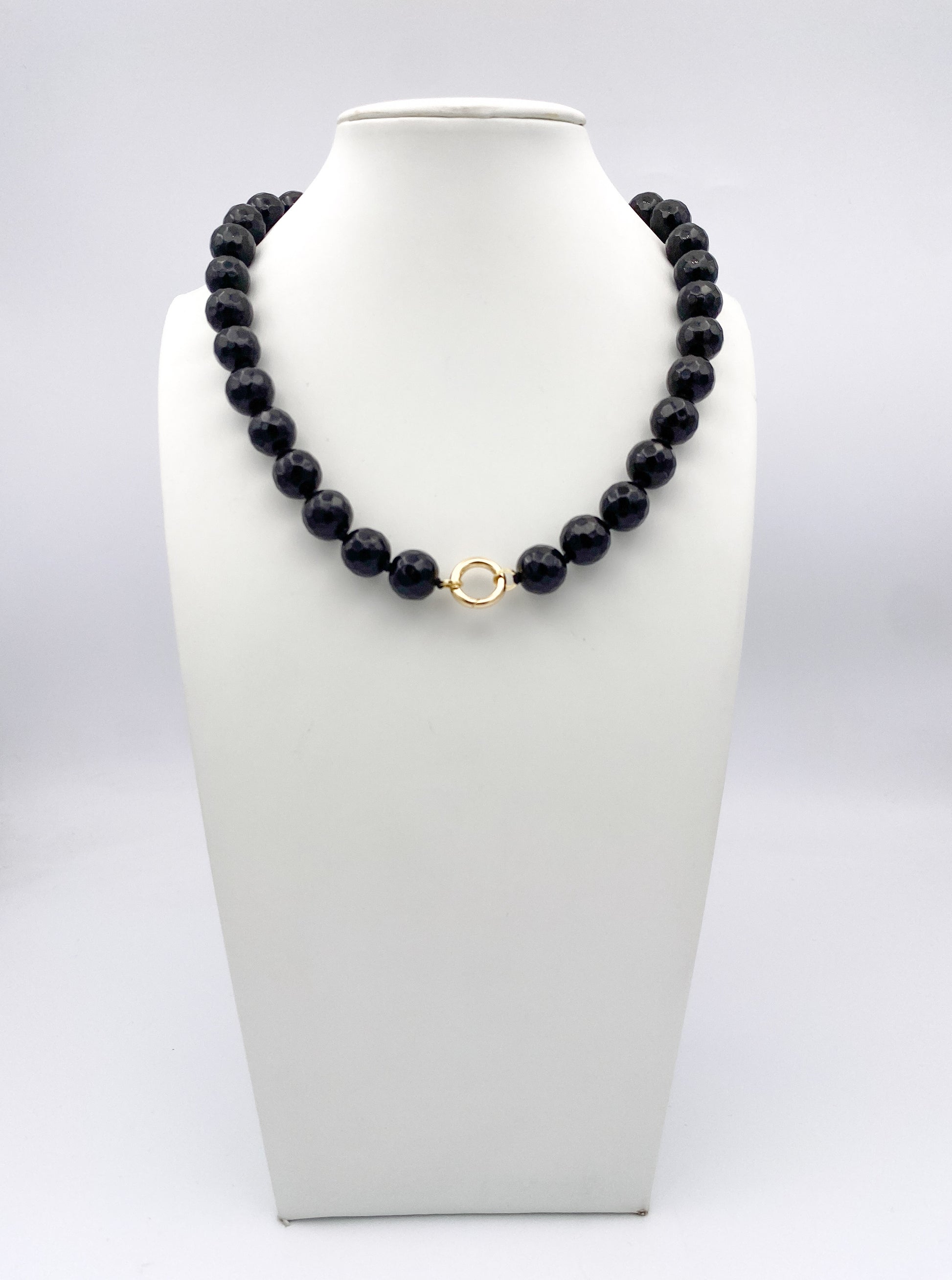AF Designs Midnight Noir faceted dark navy bead necklace with gold circular clasp on white jewelry bust
