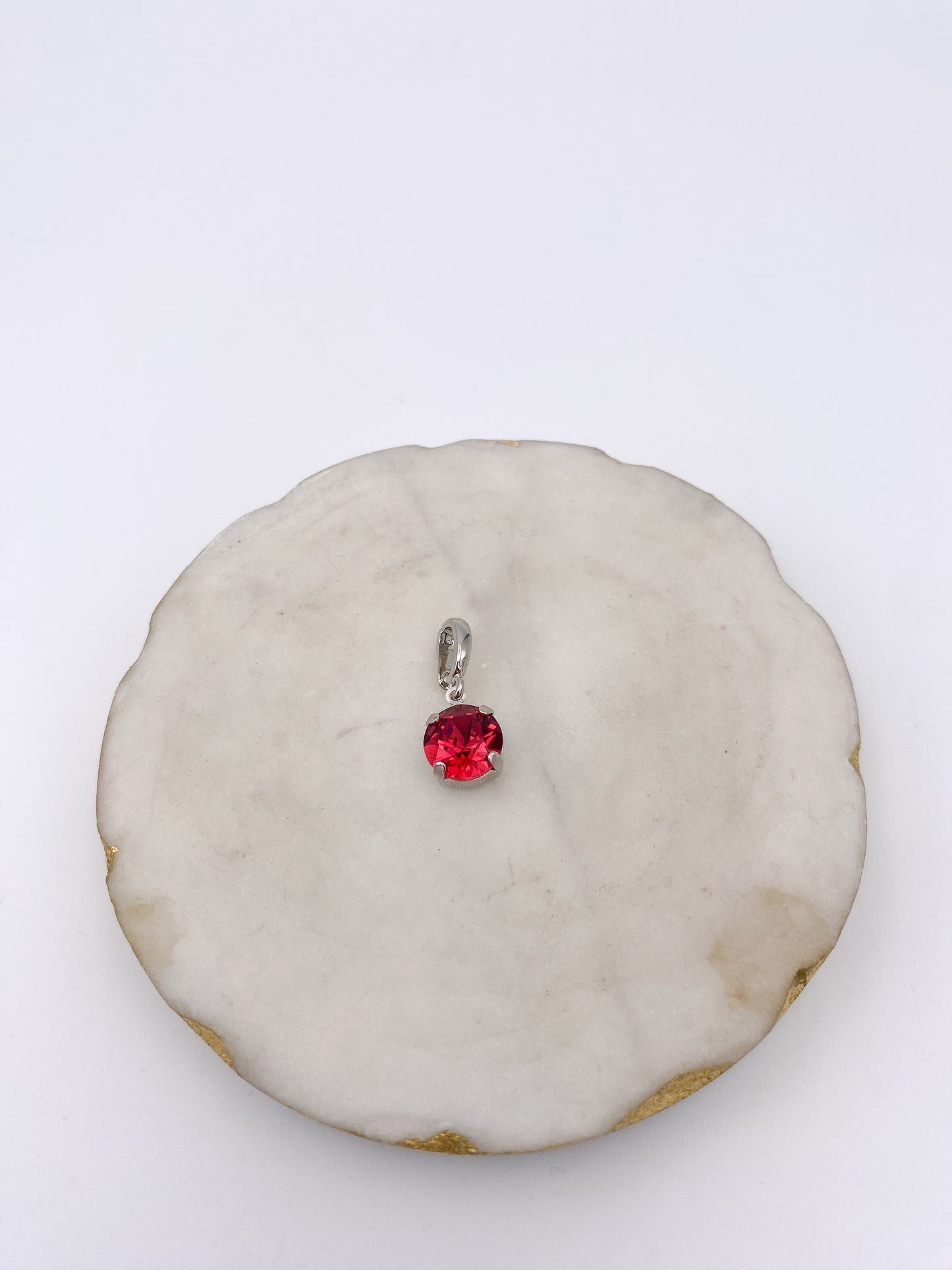 Dainty silver pendant charm with round-cut ruby red gemstone in four-prong setting by AF Designs