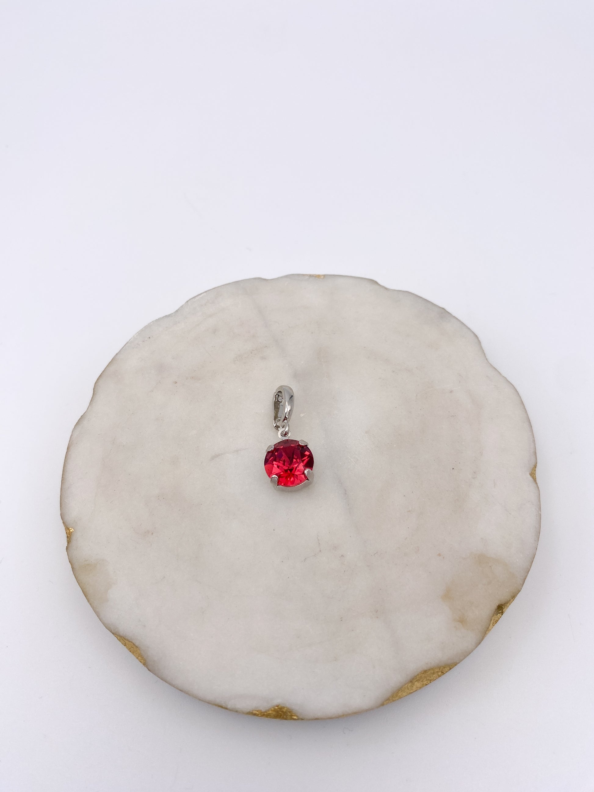 Dainty silver pendant charm with round-cut ruby red gemstone in four-prong setting by AF Designs