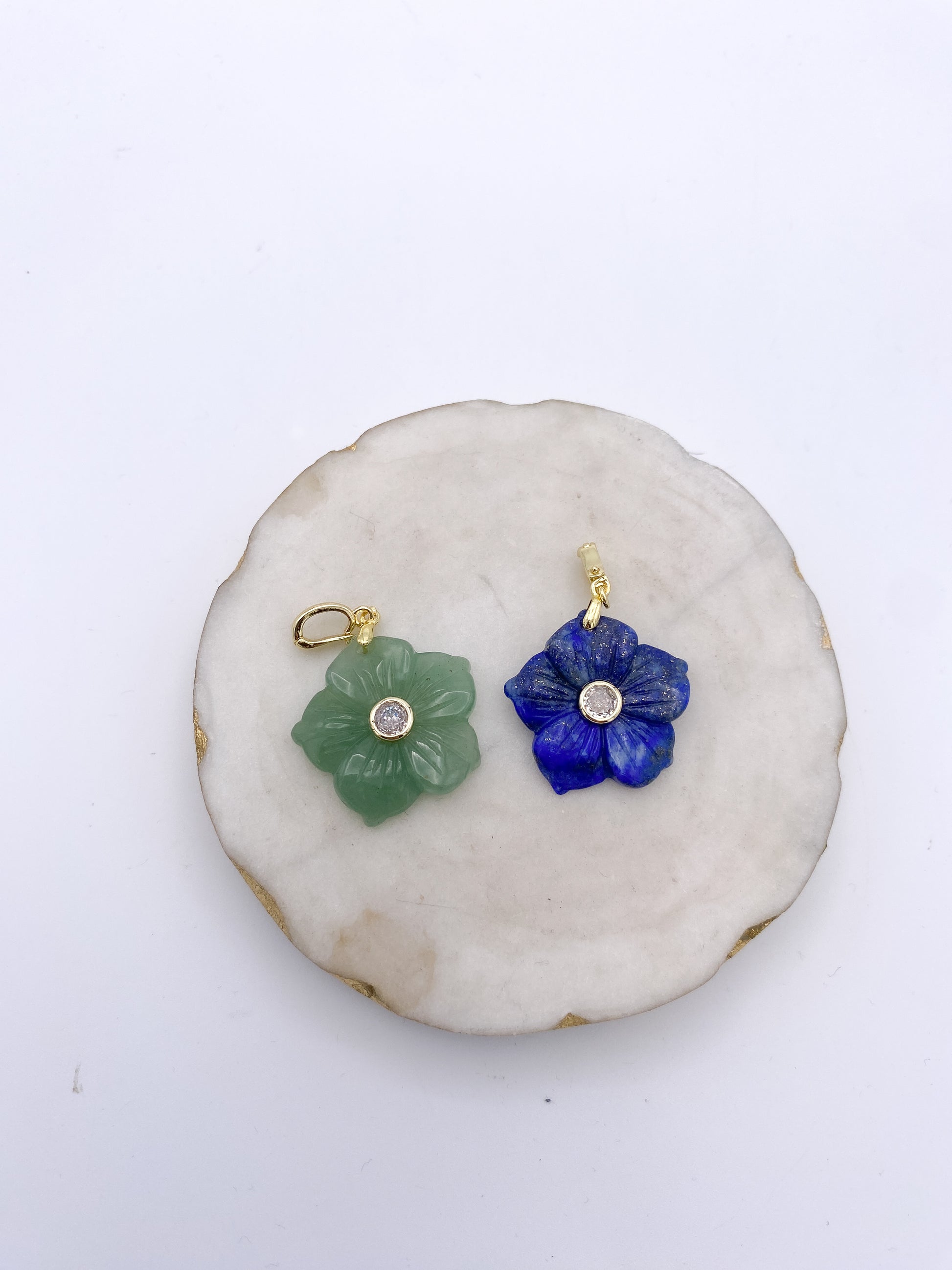 Carved lapis lazuli blue flower pendant charm with gold setting and crystal center stone.