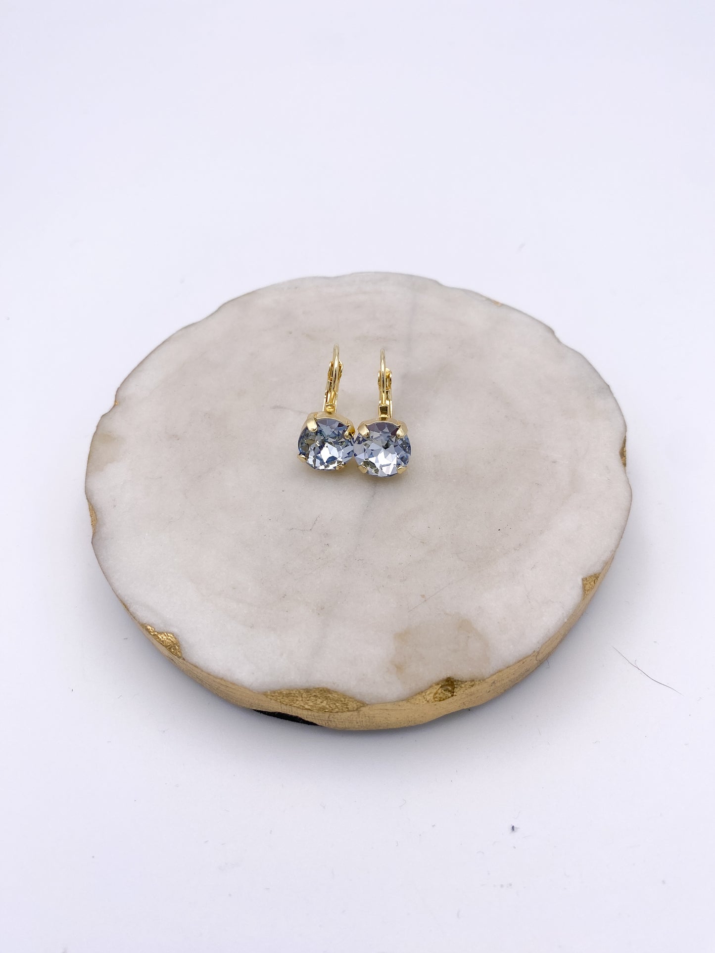 Gold lever-back drop earrings with faceted blue-gray raindrop crystal stones in prong settings