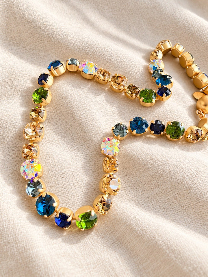 AF Designs gold tennis necklace with multicolor crystals in blue, green, aurora borealis, and champagne tones.