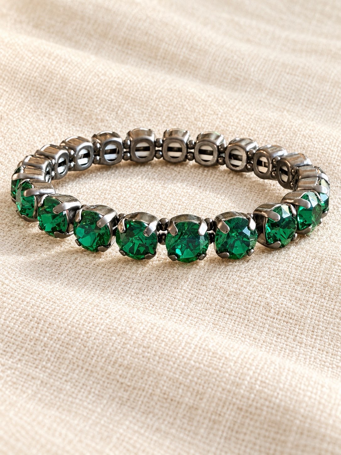 Drama Club stretch bracelet with round emerald green crystals in dark gunmetal silver prong settings