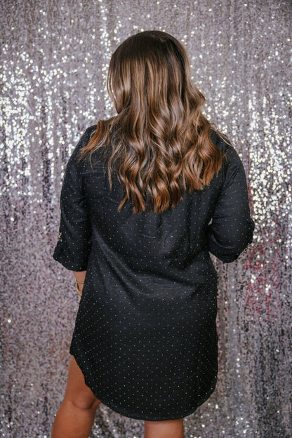 Back view of the black rhinestone shirt dress showing allover rhinestone sparkle and rolled cuff sleeves